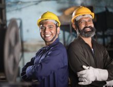 Portrait of two male engineers with arms crossed at factory